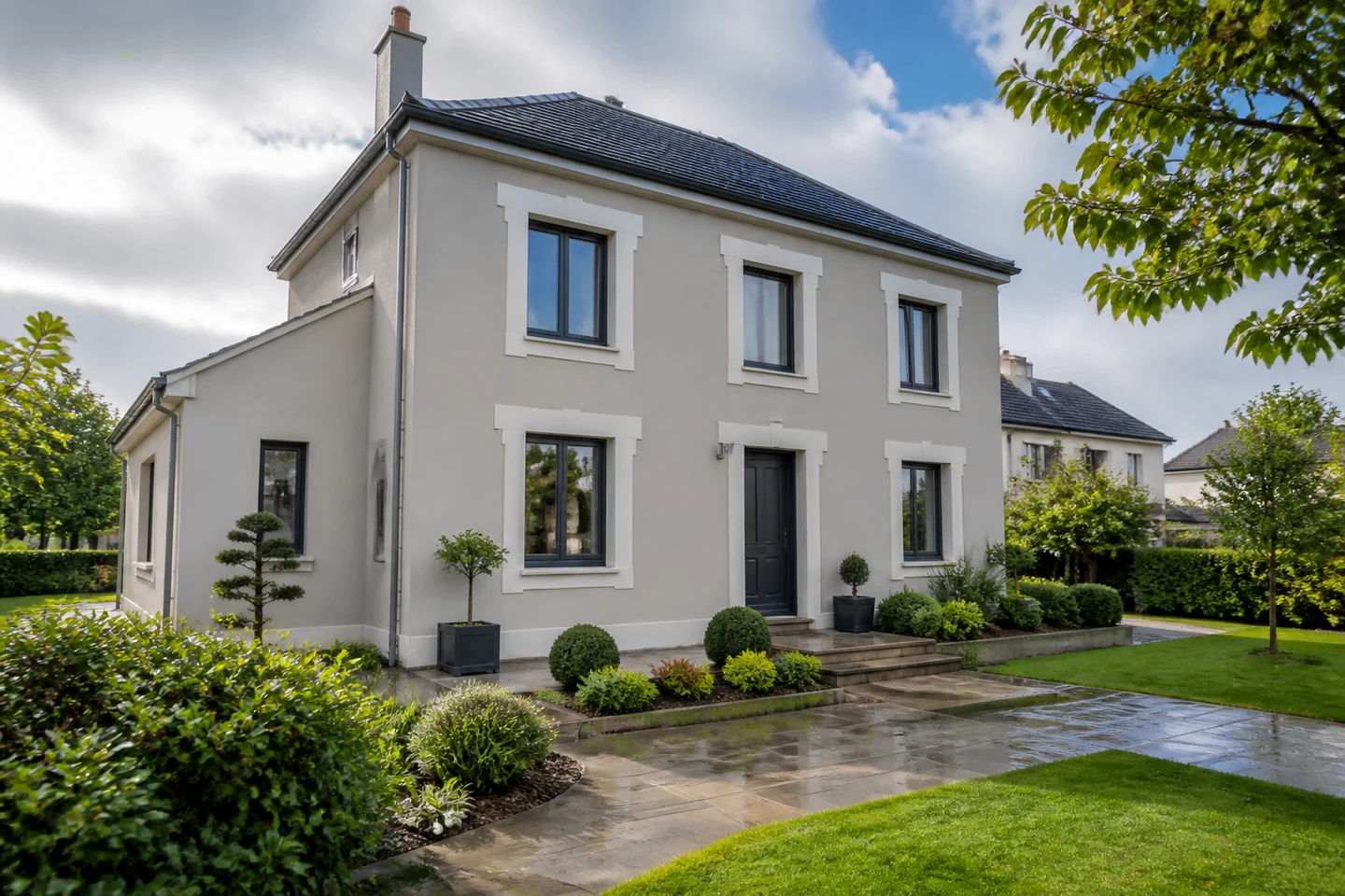 Maison rénovée associant enduit clair et accent de bardage bois